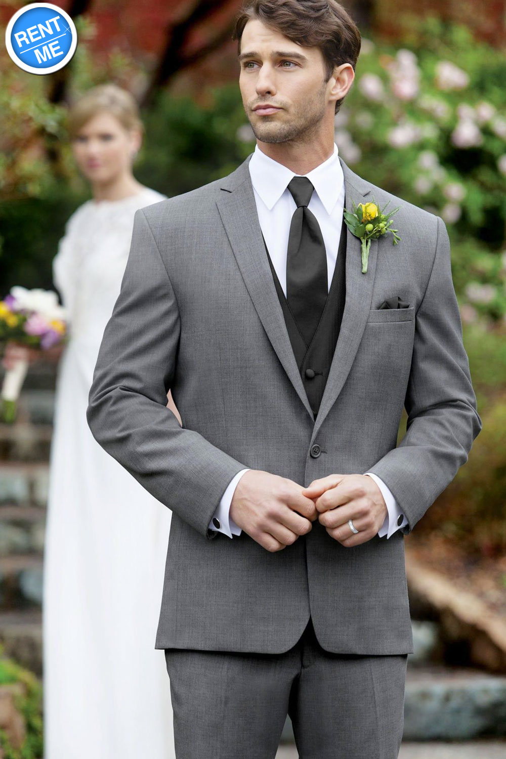 A man wearing a grey suit and a black dress shirt, embracing his partner